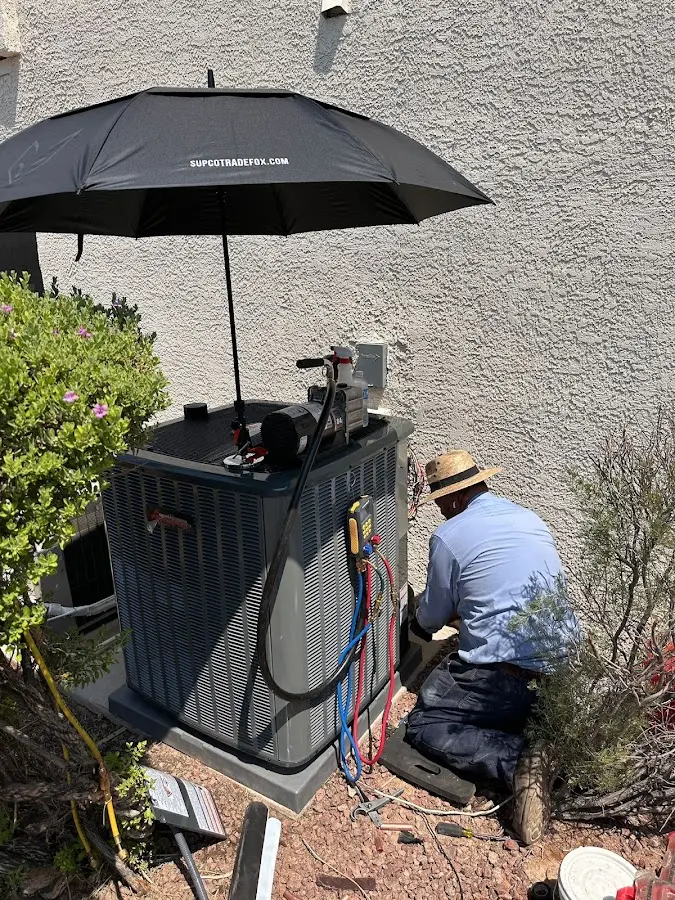 HVAC technician performing outdoor AC maintenance in Affton
