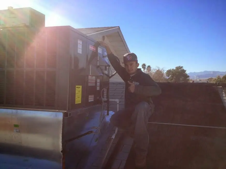 HVAC technician performing Air Duct Cleaning on a rooftop unit in Affton